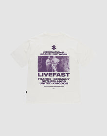 Das LFDY Grand Theft Tee von LIVE FAST DIE YOUNG ist ein weißes Oversize-Shirt aus 100% Baumwolle mit lila Backprint eines Skateboarders und Prints mit "INTERNATIONAL BRANCH NETWORK, LIVEFAST" sowie Ländernamen wie France und Germany. | plain