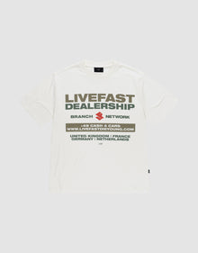 The LFDY Network Tee by LIVE FAST DIE YOUNG is an oversized white t-shirt with a bold "LIVEFAST DEALERSHIP" and "BRANCH NETWORK" front print above a web address and country list, made from 100% cotton for comfort and style. | plain