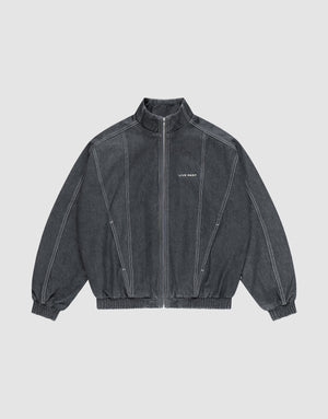 The LFDY Denim Trackjacket by LIVE FAST DIE YOUNG is dark gray, 100% Baumwolle, with a front zipper, stand collar, elastic cuffs and hem, white seams, and "LIFE PAINT" in white text on the left chest. Shown laid flat on a light background. | plain