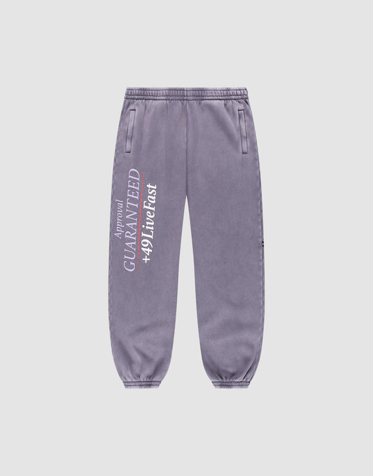 The LFDY Hotline Loose Jogger by LIVE FAST DIE YOUNG features a loose fit, elastic waistband, side pockets, and white vertical "GUARANTEED +49 Live Fast" print with smaller text on the left leg. | plain