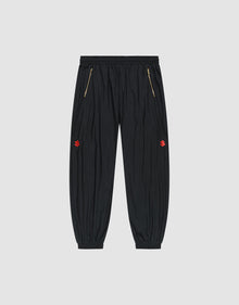 The LFDY Dealership Trackpants by LIVE FAST DIE YOUNG feature an elastic waistband, gold zippered side pockets, ankle cuffs, and small red embroidered thigh logos. Made from comfortable polyamide. Shown against a light gray background. | plain