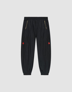 The LFDY Dealership Trackpants by LIVE FAST DIE YOUNG feature an elastic waistband, gold zippered side pockets, ankle cuffs, and small red embroidered thigh logos. Made from comfortable polyamide. Shown against a light gray background. | plain