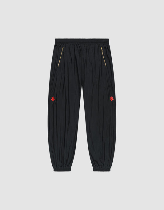 The LFDY Dealership Trackpants by LIVE FAST DIE YOUNG feature an elastic waistband, gold zippered side pockets, ankle cuffs, and small red embroidered thigh logos. Made from comfortable polyamide. Shown against a light gray background. | plain