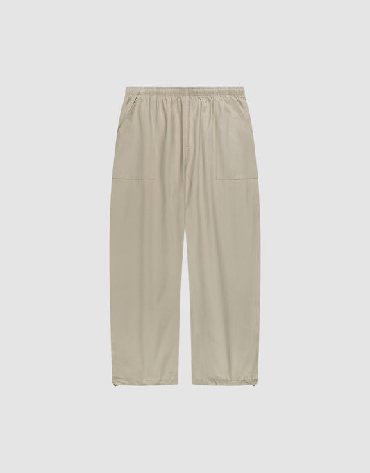 Baggy Nylon Pants by LIVE FAST DIE YOUNG in beige with a wide fit, elastic waistband, and large patch pockets, shown flat on a plain white background. | plain