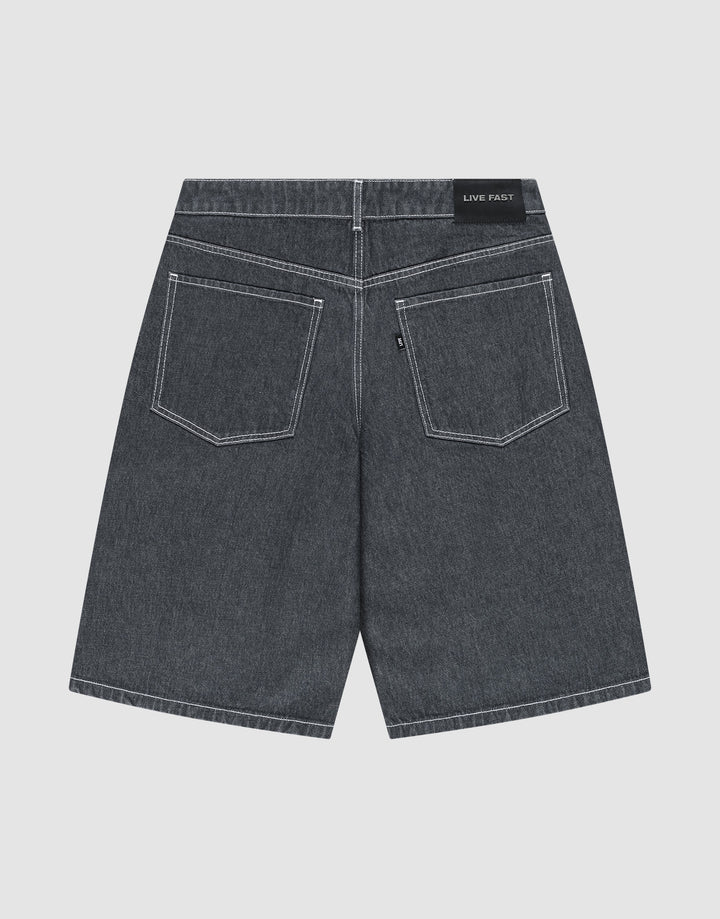 The LFDY Jorts by LIVE FAST DIE YOUNG are shown from the back, displaying a baggy fit, two large rear pockets with white stitching, and a black “LIVE FAST” Lederpatch on the waistband. The dark gray shorts are laid flat on a light background.