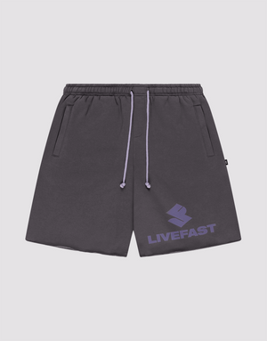 The LIVE FAST DIE YOUNG Live Fast LF Shorts are dark gray, wide fit athletic shorts featuring an elastic waistband, lavender drawstrings, side pockets, and a bold lavender LIVEFAST logo with emblem on the left leg. | plain