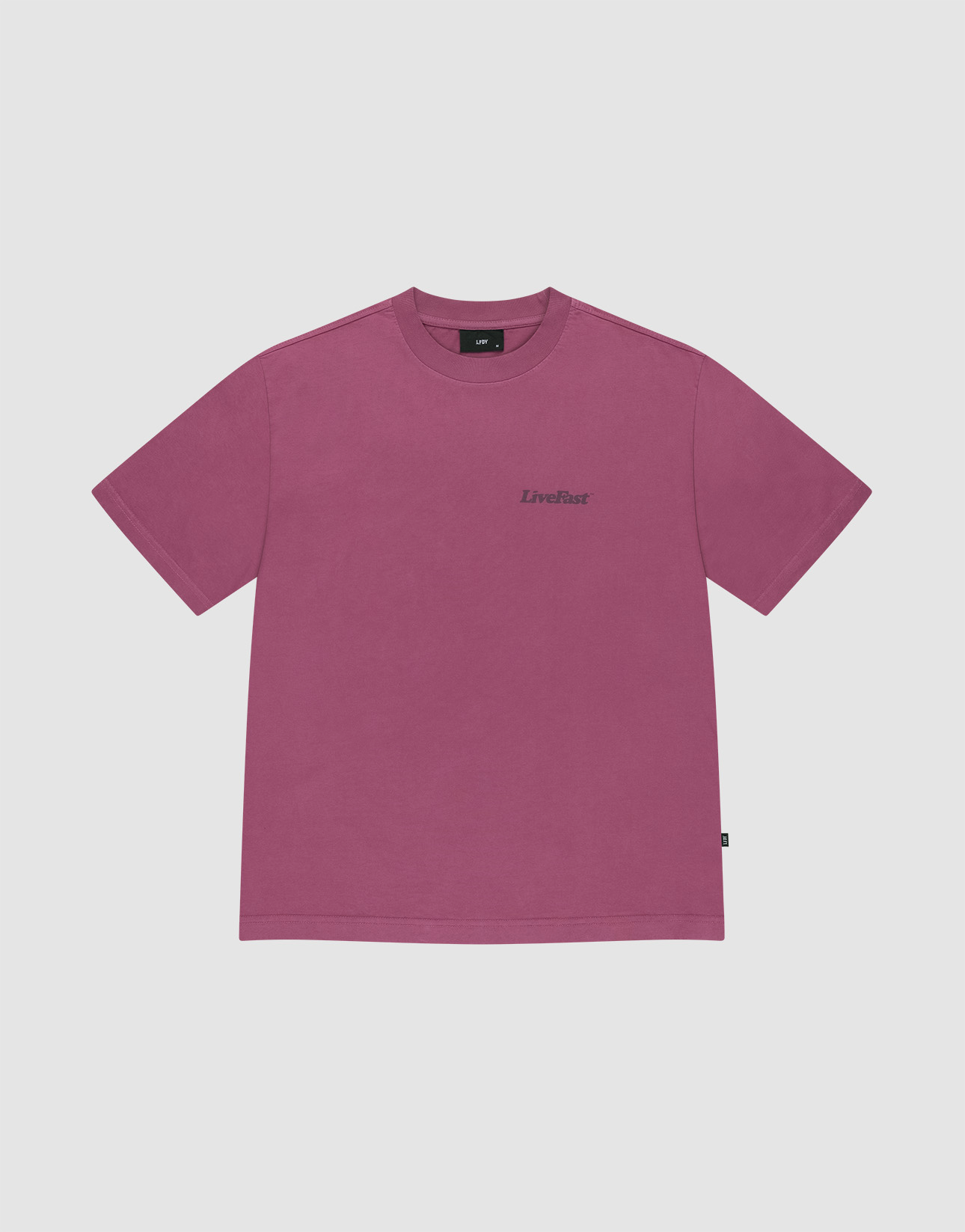 The LIVE FAST DIE YOUNG Basic 210 Tee is a mauve, oversized, short-sleeved t-shirt made from 100% Baumwolle, featuring a small black LiveFast logo on the left chest and shown against a light background.