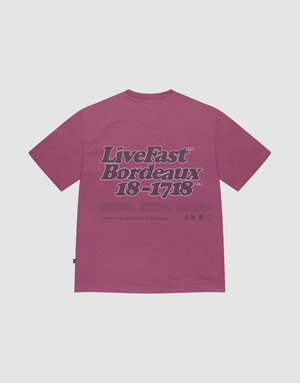 The LIVE FAST DIE YOUNG Basic 210 Tee in magenta is crafted from 100% Baumwolle. It features bold 'Live Fast Bordeaux 18–1718' text in dark purple and white with smaller details on the front and back, shown flat on a white background. | plain