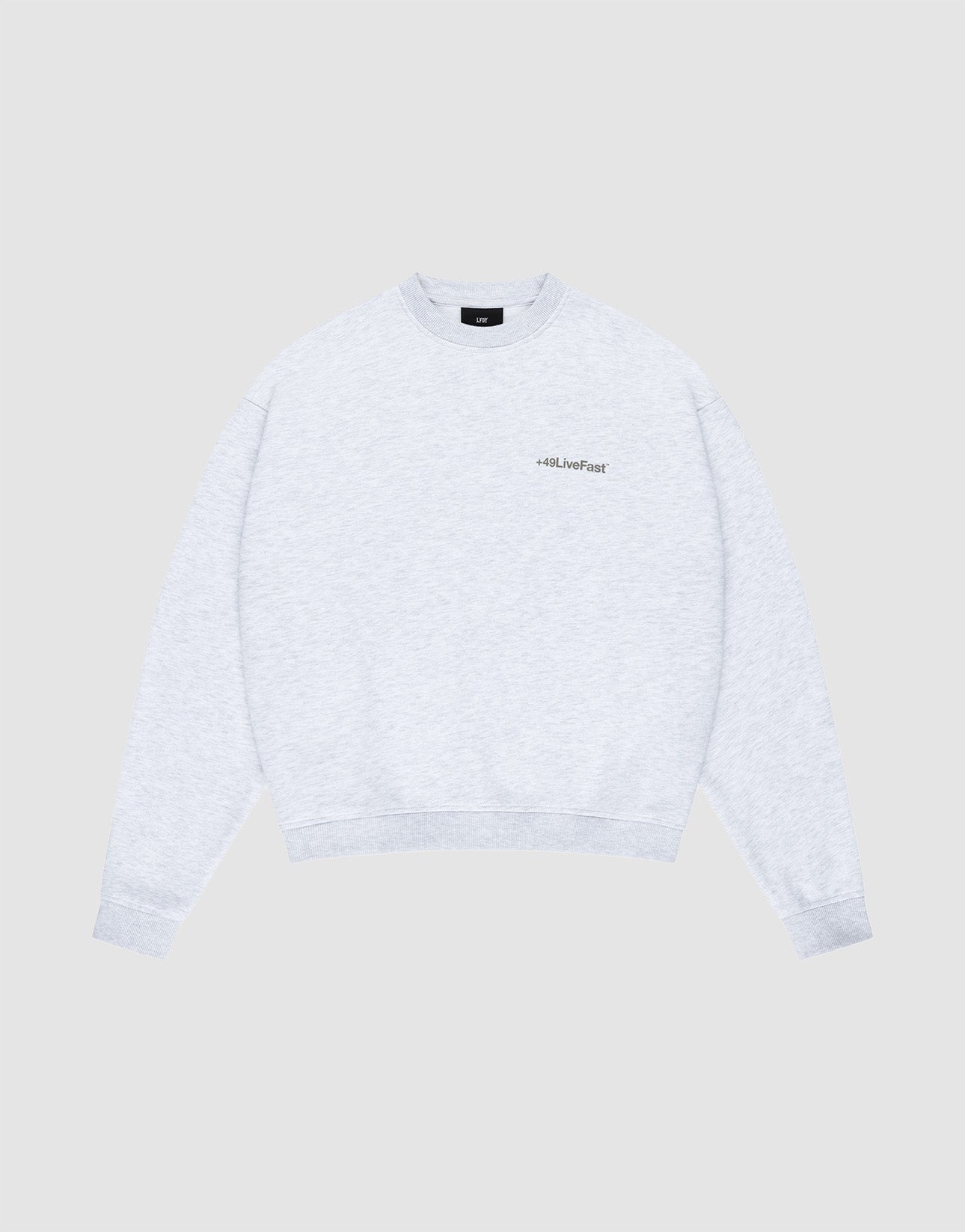 The LIVE FAST DIE YOUNG Basic +49 Chest Sweater is a light gray oversized crewneck with long sleeves and a small chestprint logo on the left, shown against a plain light gray background.