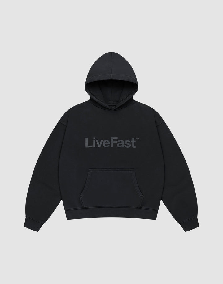 The Basic Livefast Hooded by LIVE FAST DIE YOUNG is an oversized black hoodie featuring a subtle "LiveFast" front print, crafted from soft cotton and shown against a plain light gray background. | plain