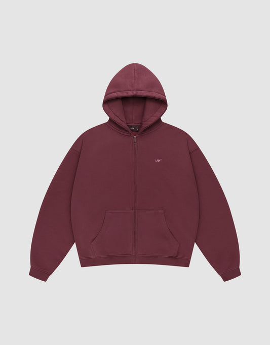 The Basic Hooded Zip by LIVE FAST DIE YOUNG is a maroon zip-up hoodie with a hood, front pockets, and small white LFDY branding on the left chest, shown on a plain light gray background. | plain