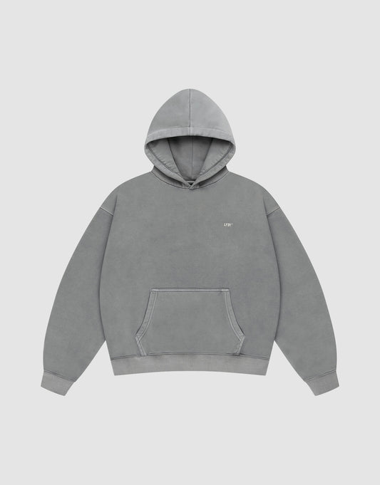 The LIVE FAST DIE YOUNG Basic Evidence Hooded is a plain gray oversized hoodie with a front pocket, hood, and small white text on the left chest. It’s styled against a plain white background.
