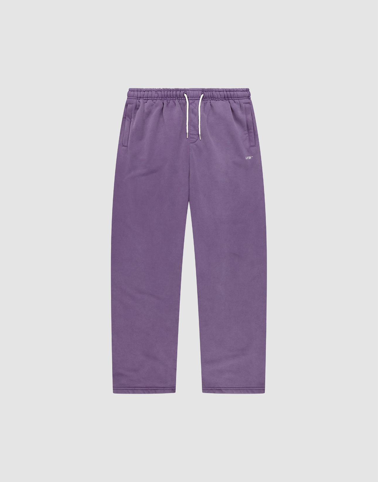 The Basic Wide Jogger by LIVE FAST DIE YOUNG features a purple color, elastic waistband, white drawstring, side pockets, and a relaxed wide fit. Shown laid flat on a plain light grey background.