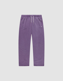 The Basic Wide Jogger by LIVE FAST DIE YOUNG features a purple color, elastic waistband, white drawstring, side pockets, and a relaxed wide fit. Shown laid flat on a plain light grey background. | plain
