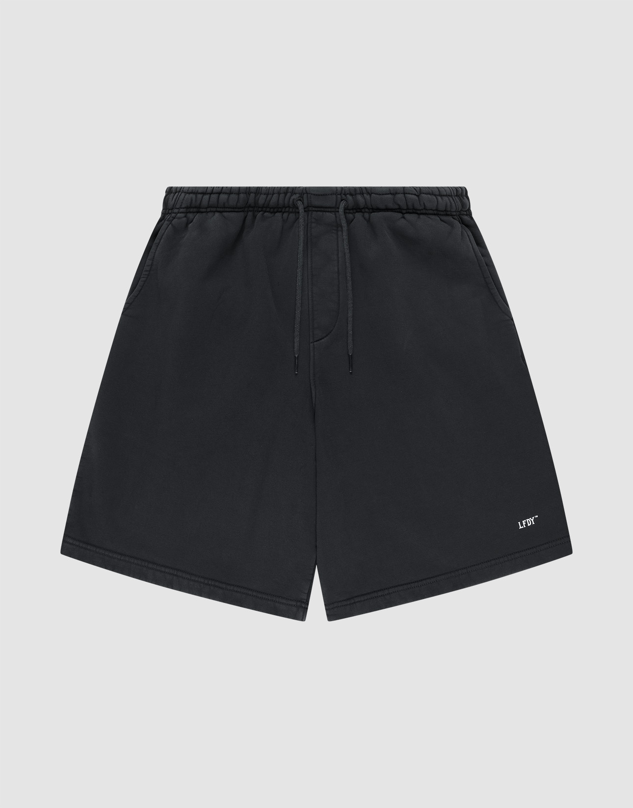 Basic Shorts by LIVE FAST DIE YOUNG in black, featuring an elastic waistband, side pockets, and a small white logo print on the lower left leg, shown against a plain light gray background.