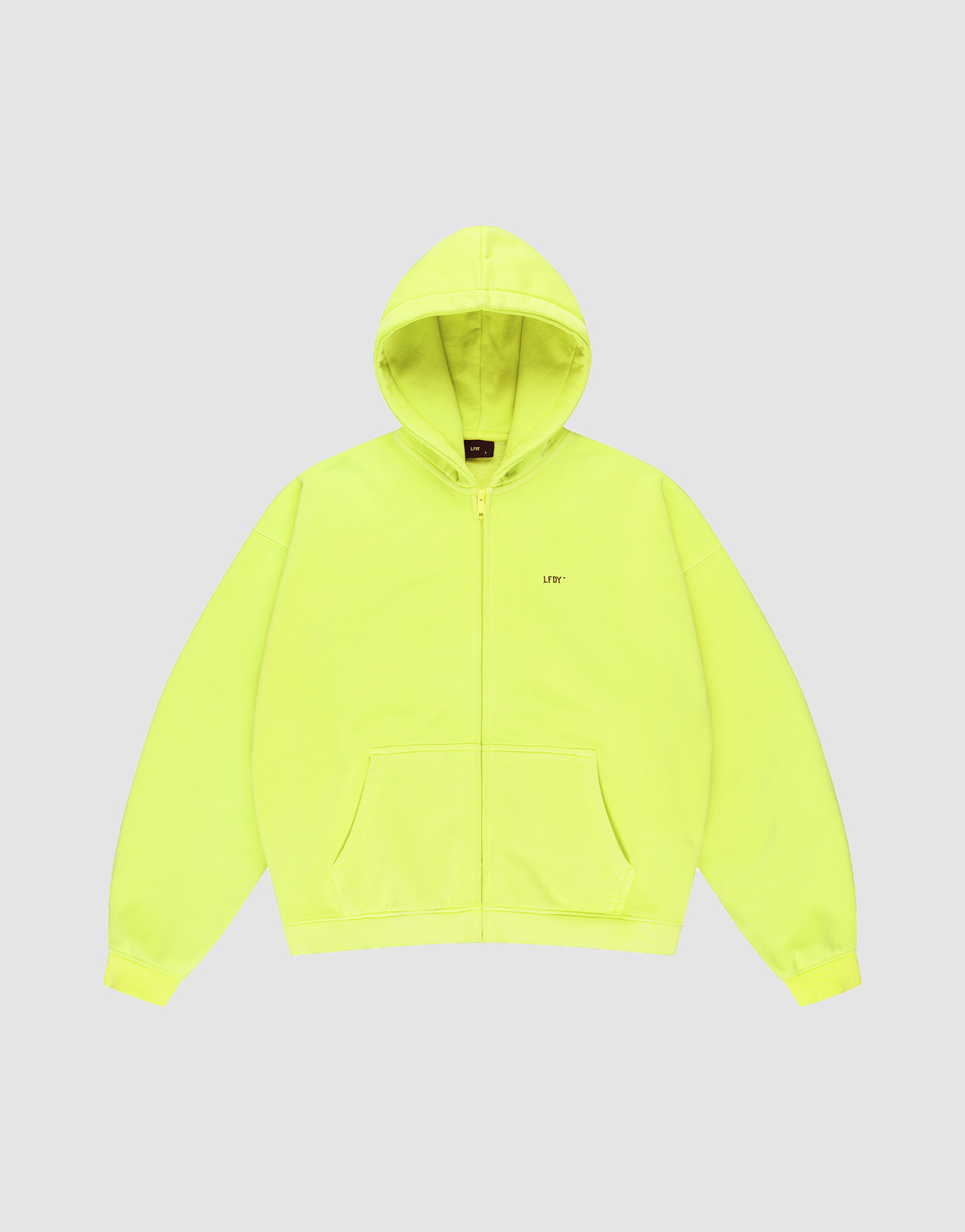 The Basic Hooded Zip by LIVE FAST DIE YOUNG is a bright yellow, oversized zip-up hoodie with a hood, front pockets, and subtle branding on the left chest, shown against a light gray background.