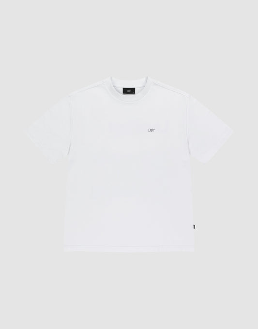 The LIVE FAST DIE YOUNG Basic Trademark Tee is an oversized white crew neck t-shirt made from 100% Baumwolle, featuring a small black LIVT logo on the left chest, shown against a light grey background.
