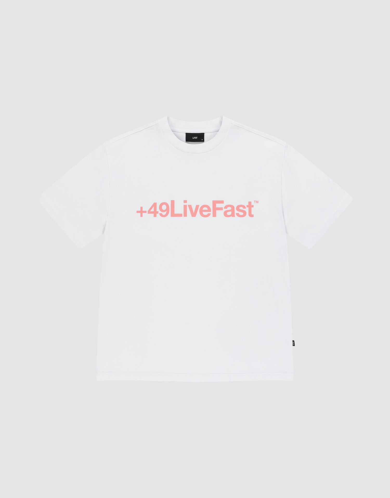 The Basic +49 Tee by LIVE FAST DIE YOUNG is an oversized white t-shirt made from 100% Baumwolle, featuring a bold pink +49LiveFast™ front print, displayed on a plain light gray background. | plain