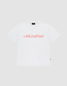 The Basic +49 Tee by LIVE FAST DIE YOUNG is an oversized white t-shirt made from 100% Baumwolle, featuring a bold pink +49LiveFast™ front print, displayed on a plain light gray background. | plain