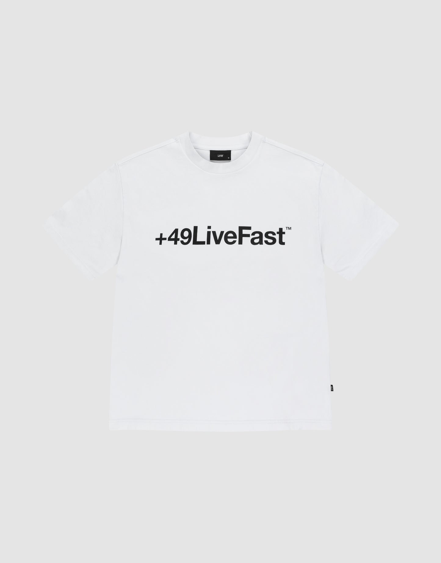The Basic +49 Tee by LIVE FAST DIE YOUNG features a bold black “+49LiveFast™” front print on white, made from 100% Baumwolle, shown against a plain light grey background.