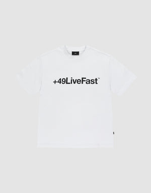 The Basic +49 Tee by LIVE FAST DIE YOUNG features a bold black “+49LiveFast™” front print on white, made from 100% Baumwolle, shown against a plain light grey background. | plain