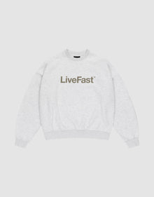 The Basic LiveFast Sweater by LIVE FAST DIE YOUNG is a light gray crewneck with an oversized fit and bold, dark LiveFast™ print on the chest, shown flat on a plain white background. | plain