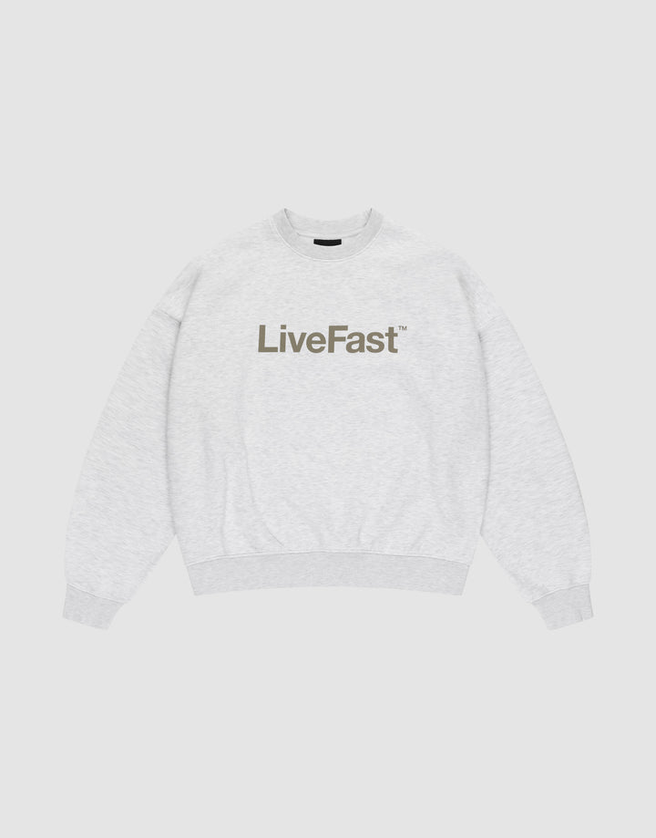 The Basic LiveFast Sweater by LIVE FAST DIE YOUNG is a light gray crewneck with an oversized fit and bold, dark LiveFast™ print on the chest, shown flat on a plain white background. | plain