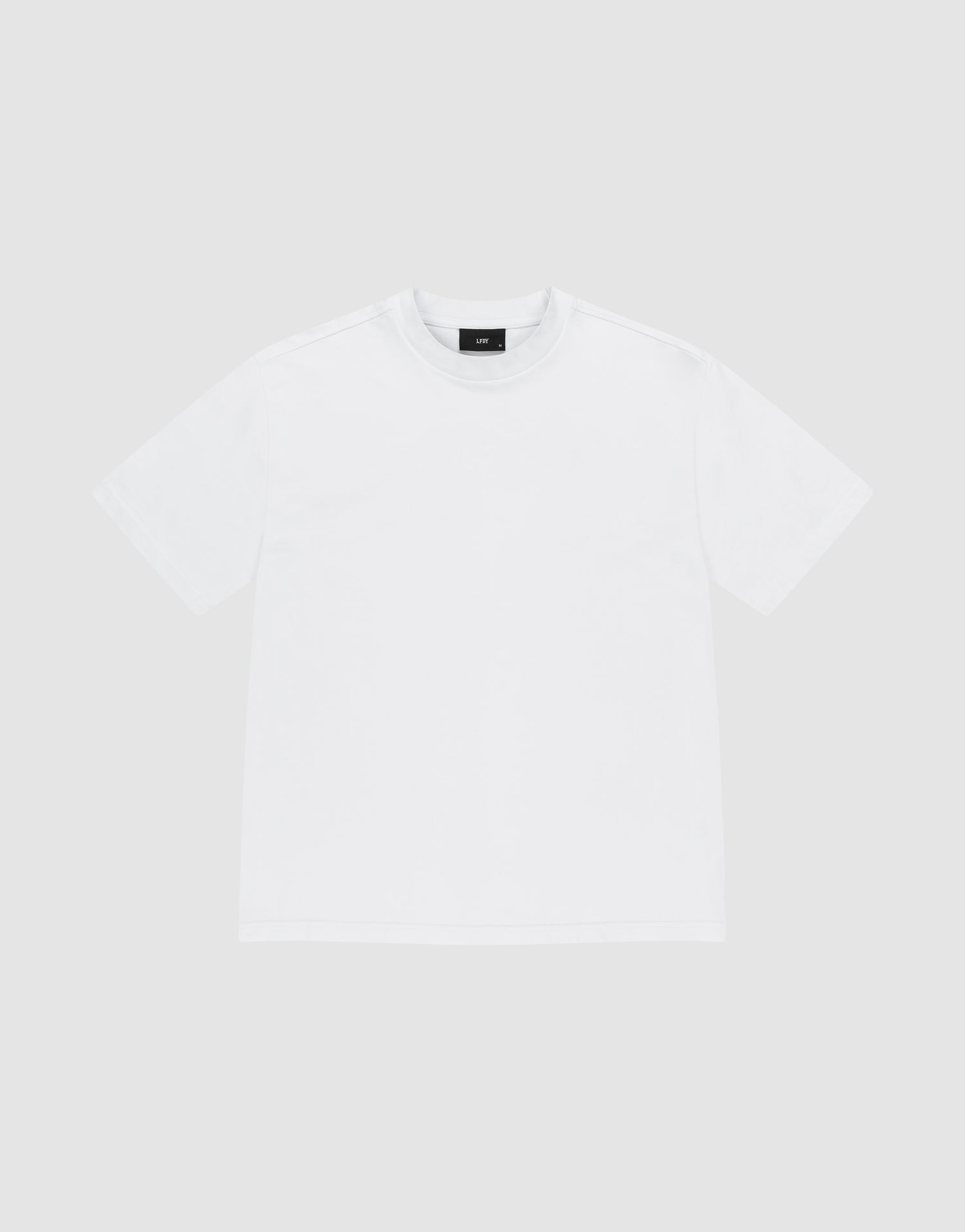 The LIVE FAST DIE YOUNG Basic Heavy Tee, an oversized white short-sleeved shirt made from 100% Baumwolle, is shown laid flat on a light gray background and viewed from the front. | plain
