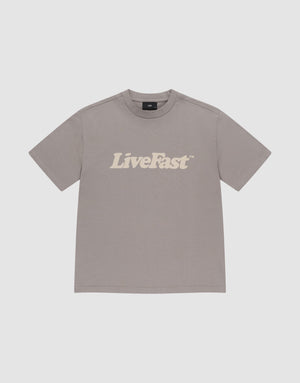 The LIVE FAST DIE YOUNG Basic Tee is an oversize, plain gray T-shirt made from 100% Baumwolle, featuring bold white "LiveFast™" lettering across the chest, shown laid flat on a light gray background. | plain