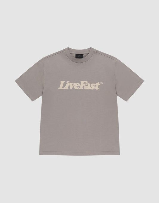 The LIVE FAST DIE YOUNG Basic Tee is an oversize, plain gray T-shirt made from 100% Baumwolle, featuring bold white "LiveFast™" lettering across the chest, shown laid flat on a light gray background. | plain