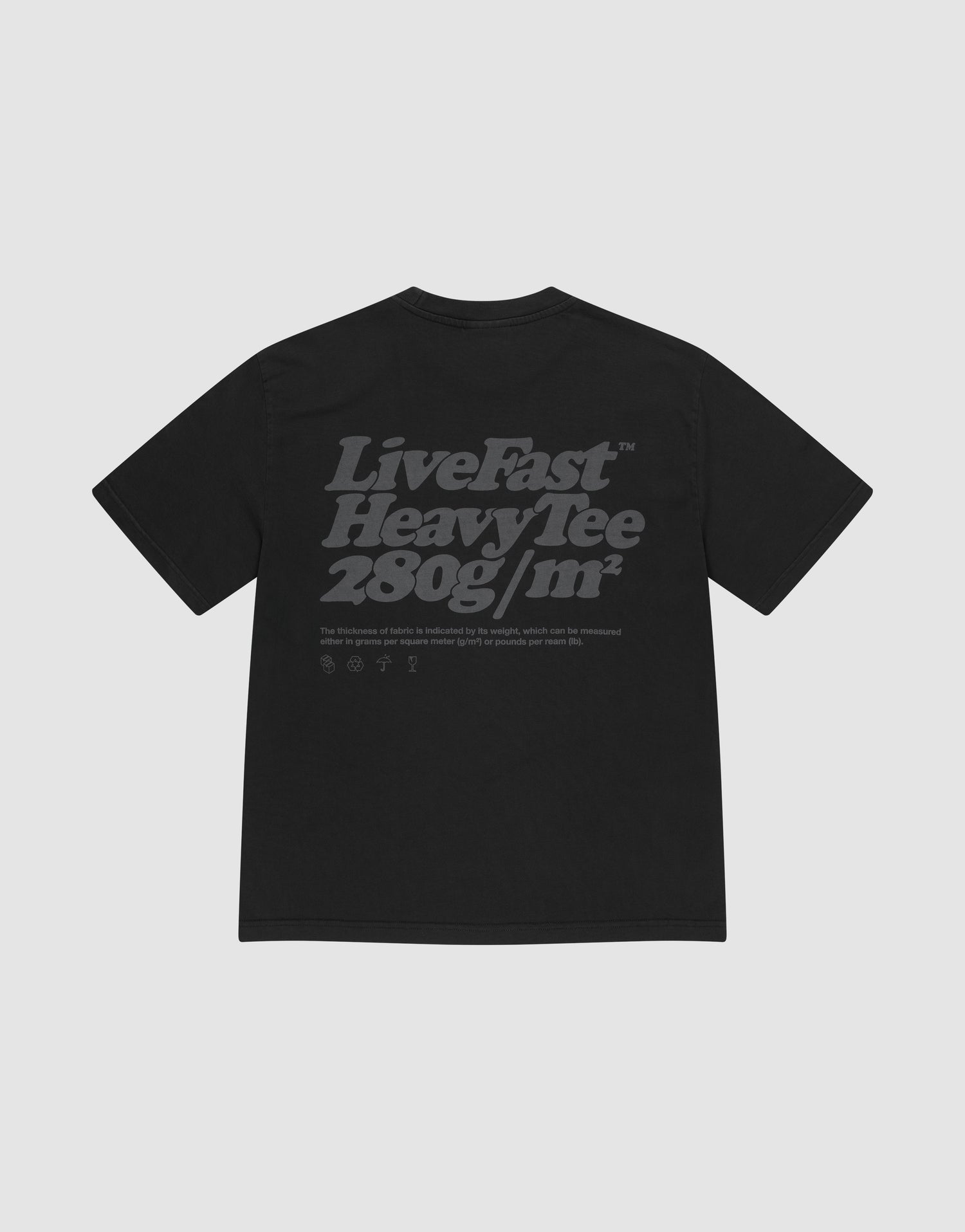 The Basic 280 Tee by LIVE FAST DIE YOUNG is a black oversized t-shirt made from 100% cotton, featuring bold gray "Live Fast Heavy Tee 280g/m²" backprint with smaller text/icons, plus prints on both sides. Shown on a light gray background.