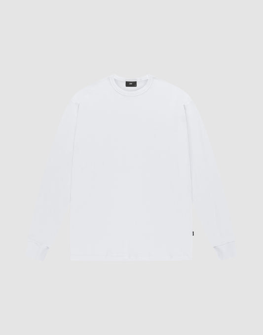 The LIVE FAST DIE YOUNG Blank Waffle Longsleeve is a white, oversized, crewneck shirt made from 100% Baumwolle. Laid flat on a light gray background, it features a small black flag-label on the lower side seam and no visible logos or designs. | plain