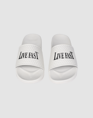 The LFDY Slides by LIVE FAST DIE YOUNG feature white PU textured straps with “LIVE FAST” in bold black letters, a comfortable EVA sole, and model number LF2606-20682.
