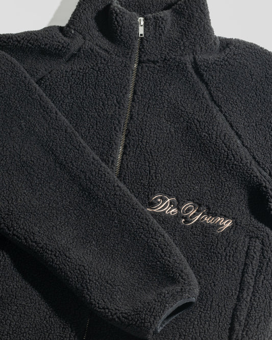 The LFDY Teddy Jacket by LIVE FAST DIE YOUNG is a black oversized jacket with textured fabric, raglan sleeves, a zipper, and “Die Young” embroidered in cursive on the front.