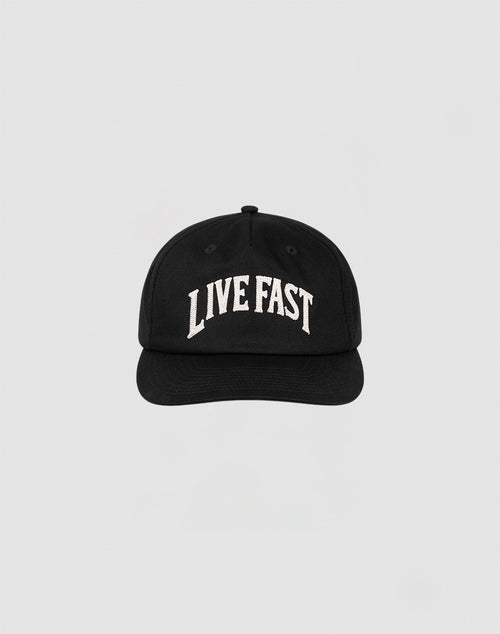 The Live Fast Unstructured Cap by LIVE FAST DIE YOUNG is a black baseball cap featuring a Flag Label and bold white LIVE FAST Logo-Stick embroidery on the front, shown against a plain light gray background.