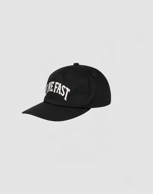 The Live Fast Unstructured Cap by LIVE FAST DIE YOUNG is a black cap with LIVE FAST embroidered in white on the front, a flag label, and an adjustable snap closure, shown against a plain light gray background.