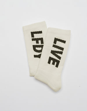 The LIVE FAST DIE YOUNG Basic Typo Socks (2 Pack) in white, One Size, feature bold black “LFDY” and “LIVE” text, made from soft Baumwolle and finished with a striking logo design. The socks are shown flat and slightly overlapping on a white background.