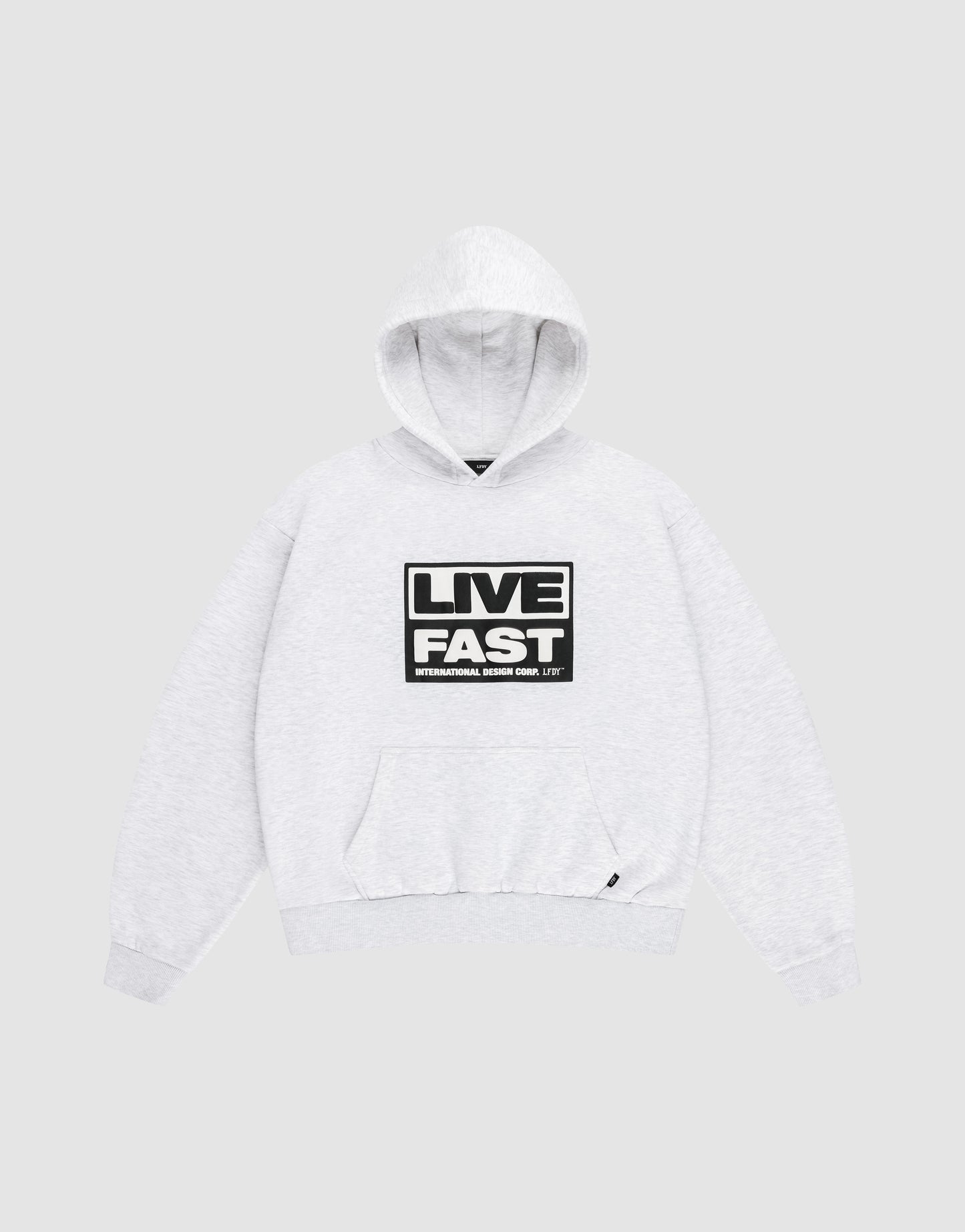 The LIVE FAST DIE YOUNG Live Fast Box Hooded sweatshirt, shown laid flat on a gray background, features an oversized fit, front pocket, and bold black and white “LIVE FAST” puffer print with smaller text beneath on the chest.