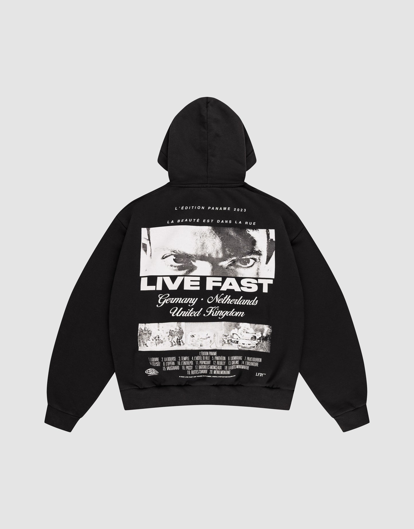 The LFDY Cinema Hooded by LIVE FAST DIE YOUNG is an oversized black cotton hoodie with intense eyes and "LIVE FAST" printed on the front, plus Germany, Netherlands, United Kingdom text and a cityscape image on the back.