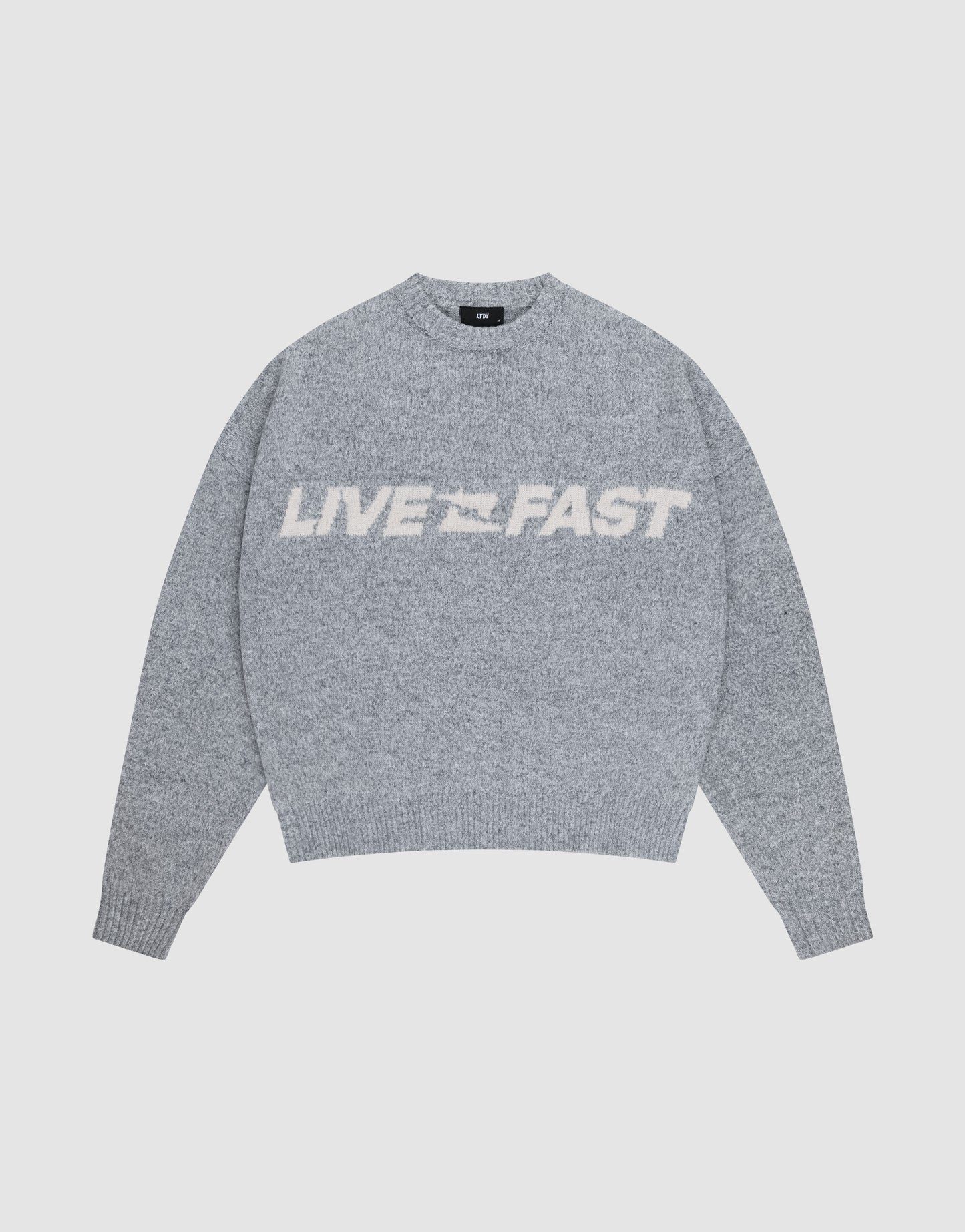 The Live Fast Boucle Sweater by LIVE FAST DIE YOUNG is a gray oversized knit with "LIVE FAST" in bold white letters across the chest, shown against a plain light background.