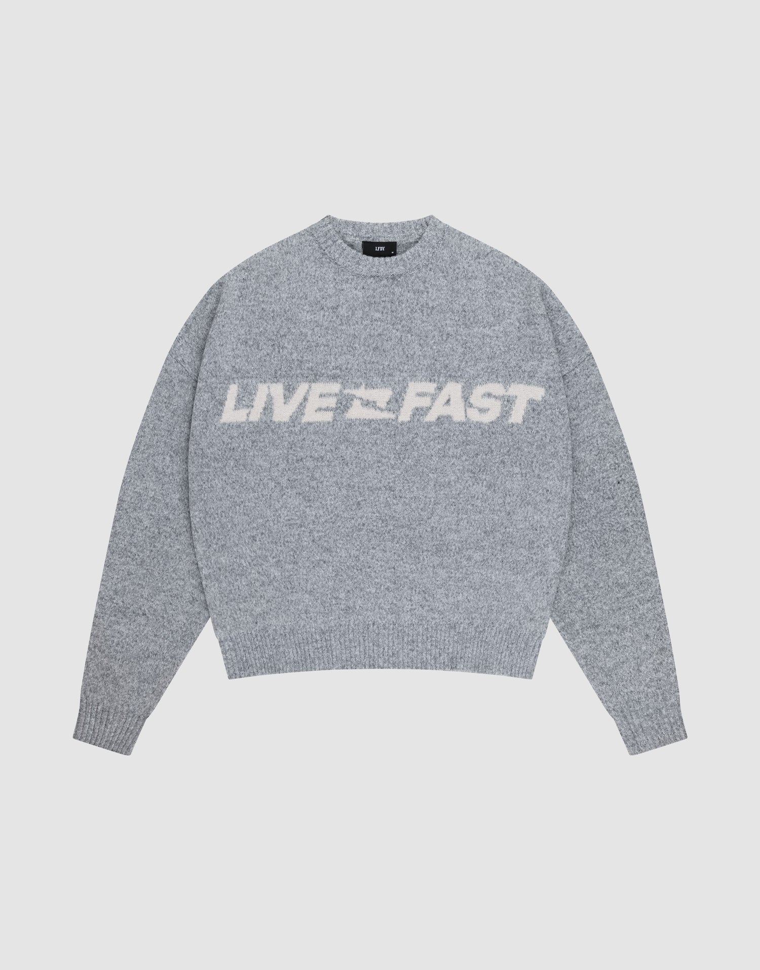 The Live Fast Boucle Sweater by LIVE FAST DIE YOUNG is a gray oversized knit with "LIVE FAST" in bold white letters across the chest, shown against a plain light background. | plain