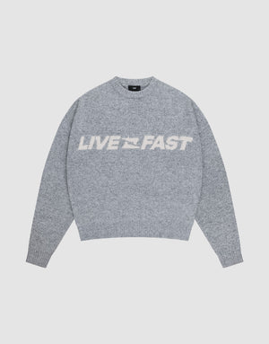 The Live Fast Boucle Sweater by LIVE FAST DIE YOUNG is a gray oversized knit with "LIVE FAST" in bold white letters across the chest, shown against a plain light background. | plain