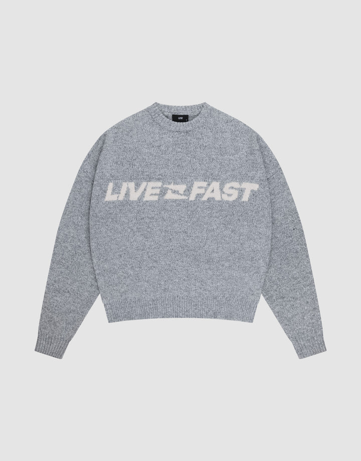 The Live Fast Boucle Sweater by LIVE FAST DIE YOUNG is a gray oversized knit with "LIVE FAST" in bold white letters across the chest, shown against a plain light background. | plain