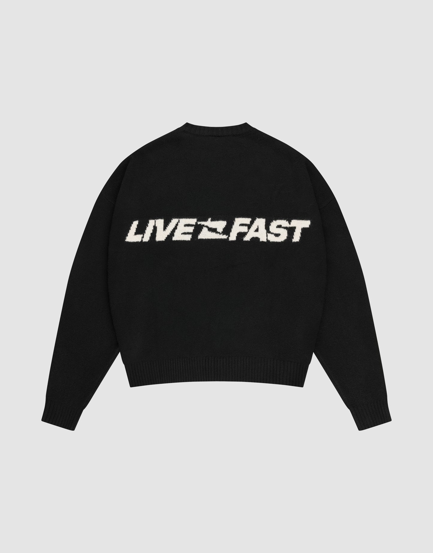 The Live Fast Boucle Sweater by LIVE FAST DIE YOUNG is a black, oversize-fit knit with "LIVE FAST" in bold white on the back, a stylized graphic between the words, and classic crew neckline plus ribbed cuffs and hem.