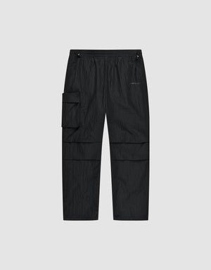 The Live Fast Nylon Pants by LIVE FAST DIE YOUNG feature an elastic waistband, adjustable drawstrings, oversized fit, multiple pockets including a large zip cargo pocket, and a small logo on the left thigh, shown against a light gray background. | plain