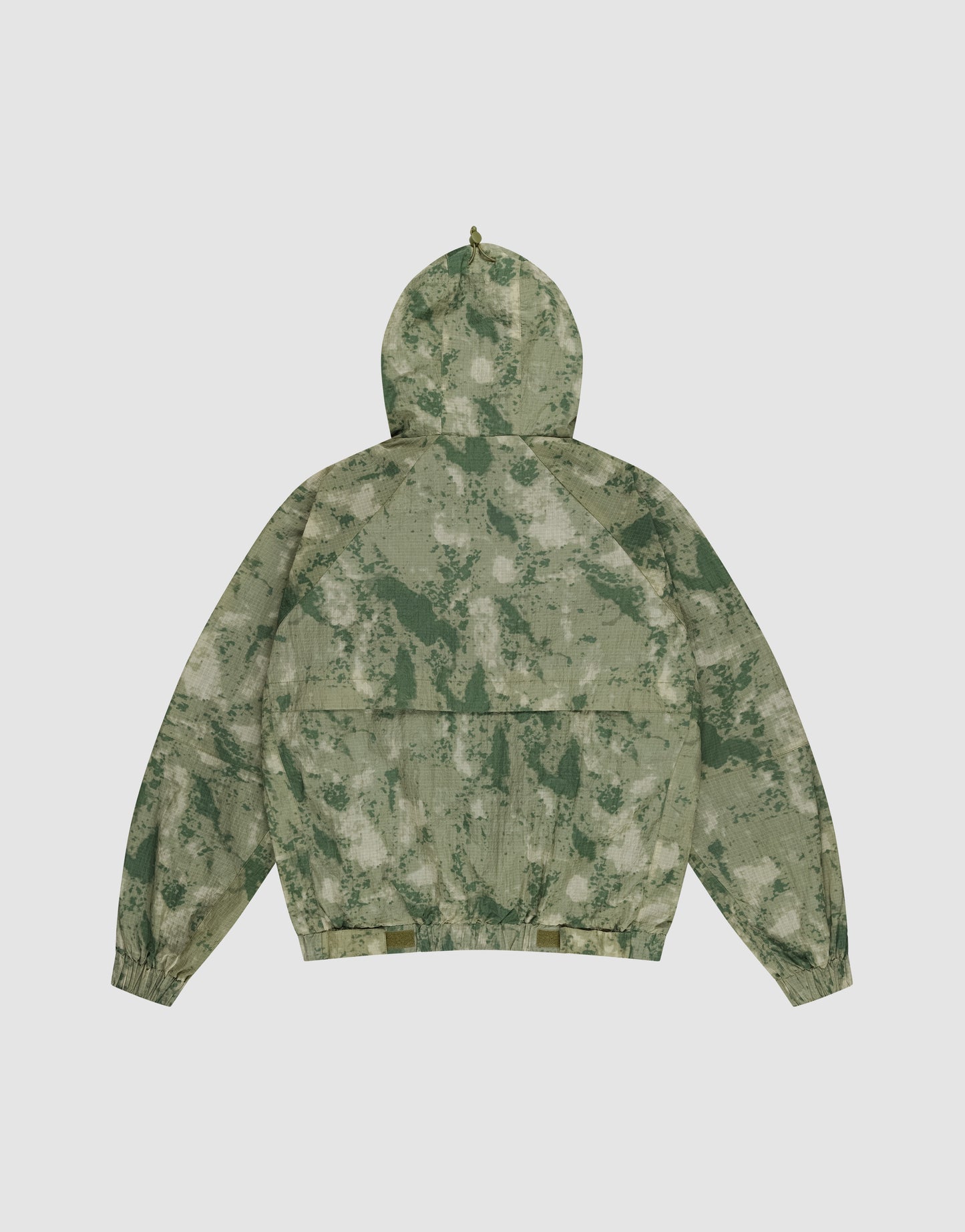 The LIVE FAST DIE YOUNG Live Fast Nylon Jacket is shown flat from the back with a green/beige camouflage pattern, elastic cuffs, Kapuze mit Tunnelzug, oversize fit, and hood against a plain white background.