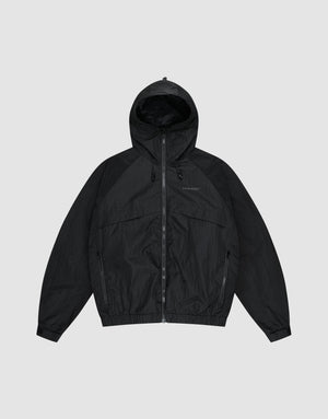 The LIVE FAST DIE YOUNG Live Fast Nylon Jacket is a black, oversized zip-up windbreaker with long sleeves, hood, Stehkragen, and side pockets, shown against a plain light gray background. | plain
