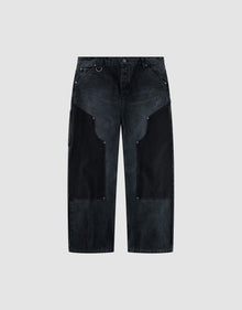 The LFDY Carpenter Pants by LIVE FAST DIE YOUNG feature a wide-leg, high-waist black denim design with dark charcoal thigh patches, silver rivet details, and are made from 100% Baumwolle. Shown on a light gray background. | plain