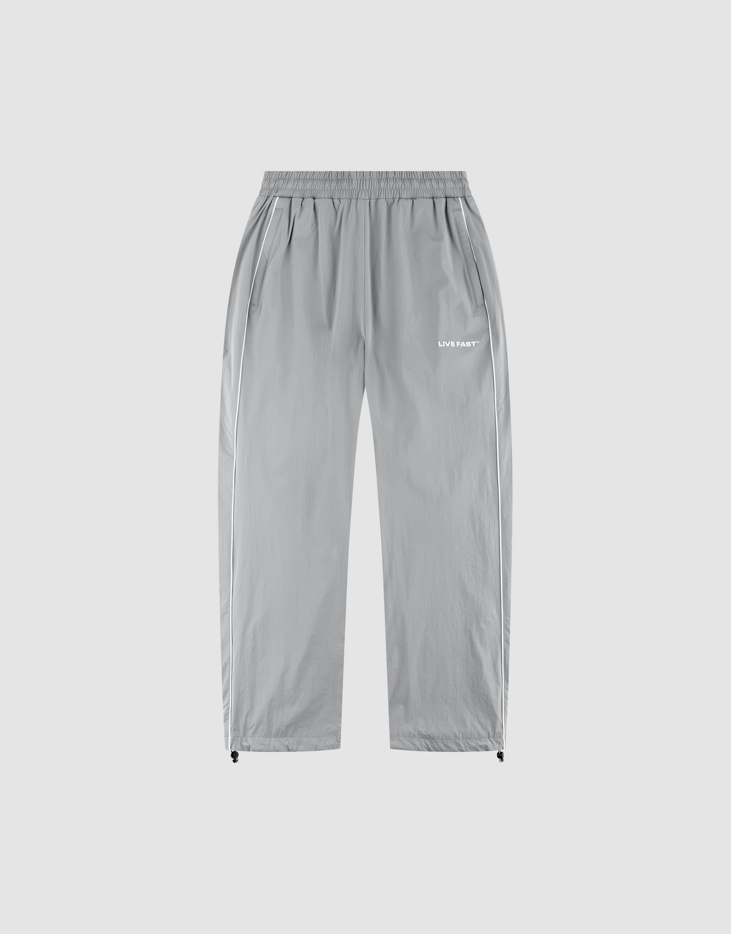 The LFDY Ripstop Trackpants by LIVE FAST DIE YOUNG feature light gray nylon, a wide elastic waistband, side pockets, adjustable ankle drawstrings, and a white "LUV IS RAGE" silicone logo on the upper left thigh for a modern look. | plain