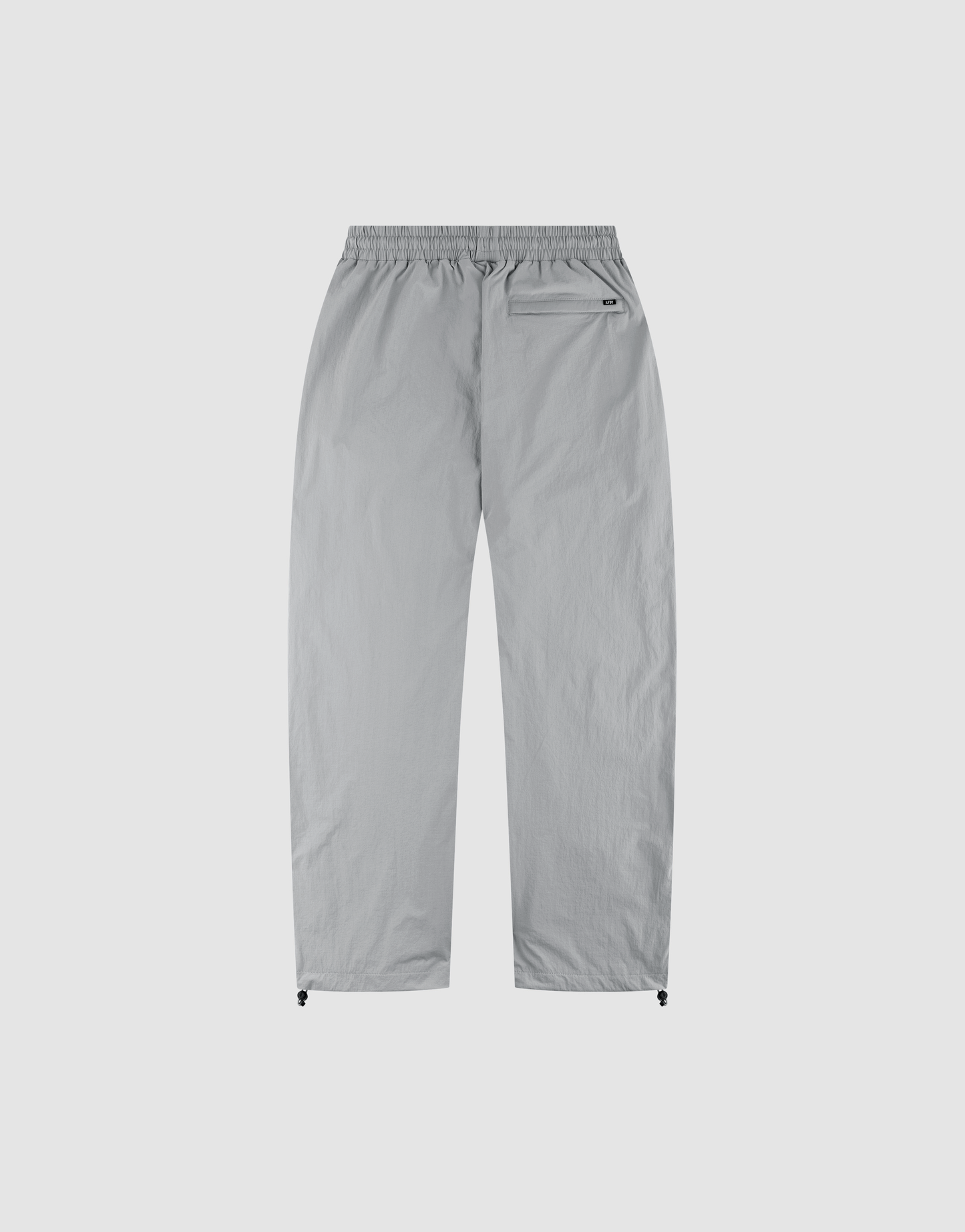 The LIVE FAST DIE YOUNG LFDY Ripstop Trackpants in light grey feature a wide elastic waistband, straight legs, a zippered back-right pocket, and adjustable ankle drawstrings—shown laid flat on a plain white background.